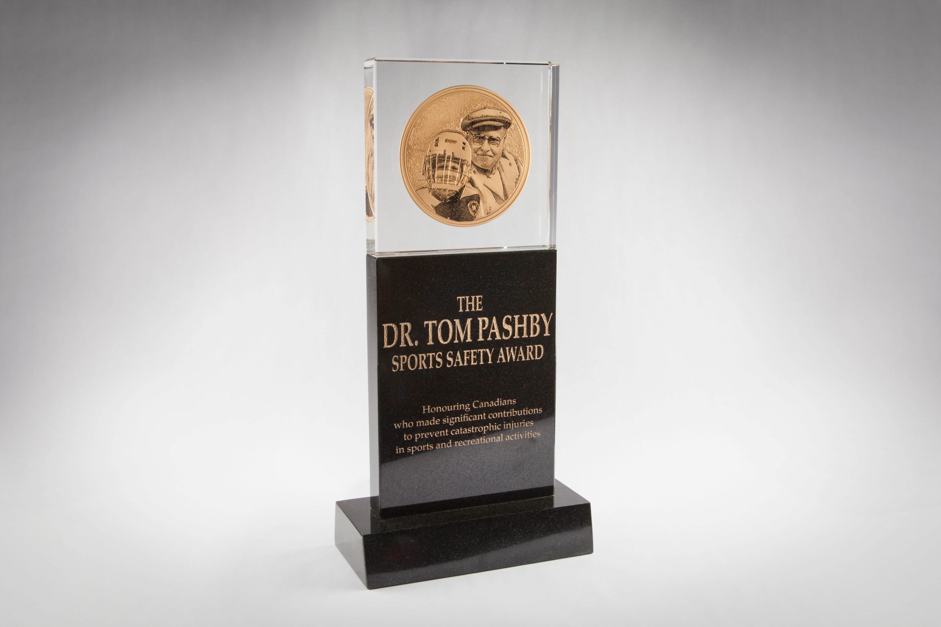 Tom Pashby Sports safety awards, customized sports awards from Crystal sensations, being combined of two materials of different finish, and sand etched and color filled with imagery and text for hocky and rugby