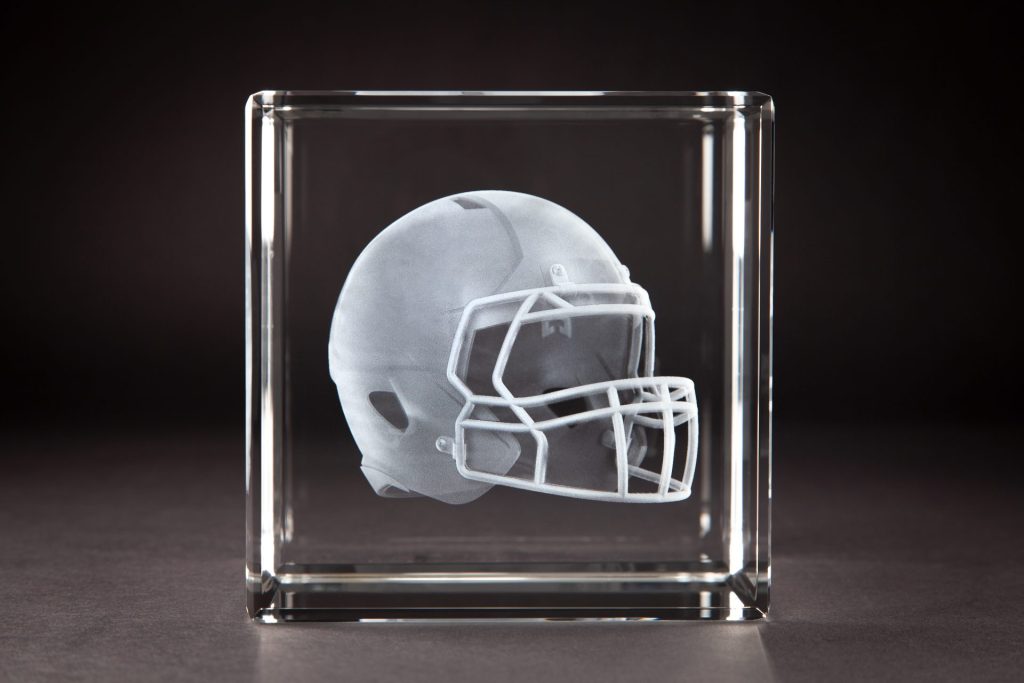 Crystal Sensations 3D laser engraved crystal cube featuring a detailed football helmet suspended inside optical crystal — custom sports crystal trophies by Crystal Sensations